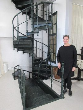 Pia Lundström visar upp den vackra spiraltrappan, som tillverkats av Skoglund & Olsson